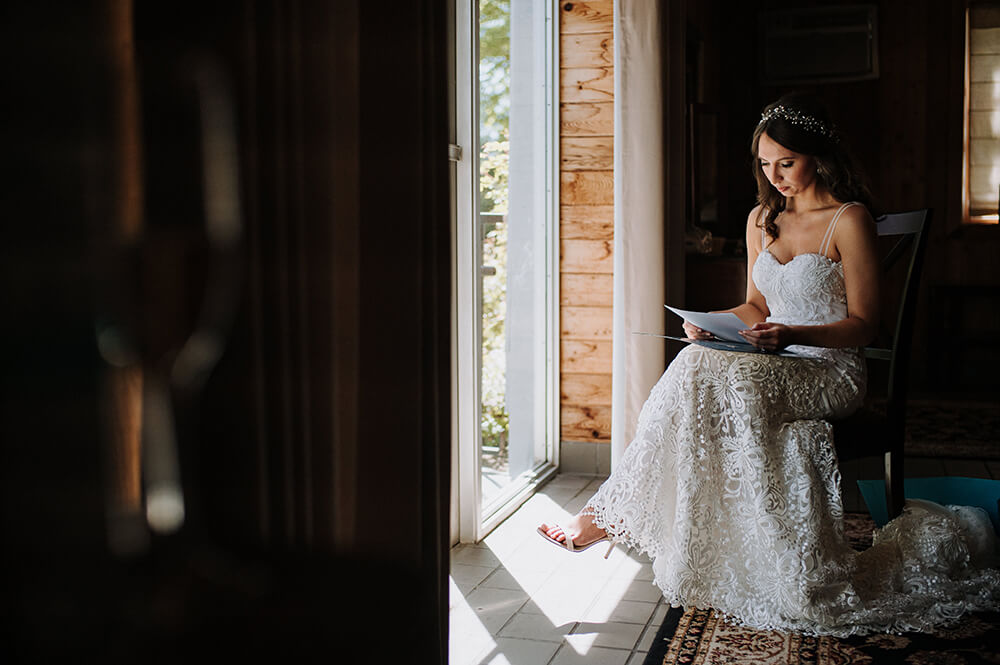 Bride reading vows in room before ceremony.