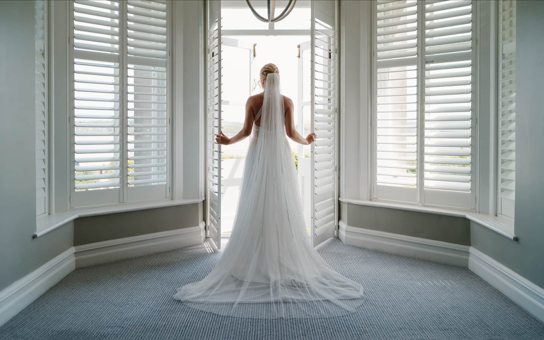 Bride looking out at view in her wedding dress.